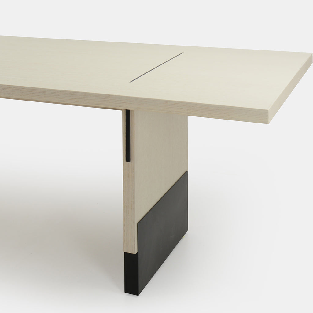 A dining table with oak veneer and metal base